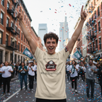 Person in a beige t-shirt with a graphic design, celebrating with confetti in an urban street setting.