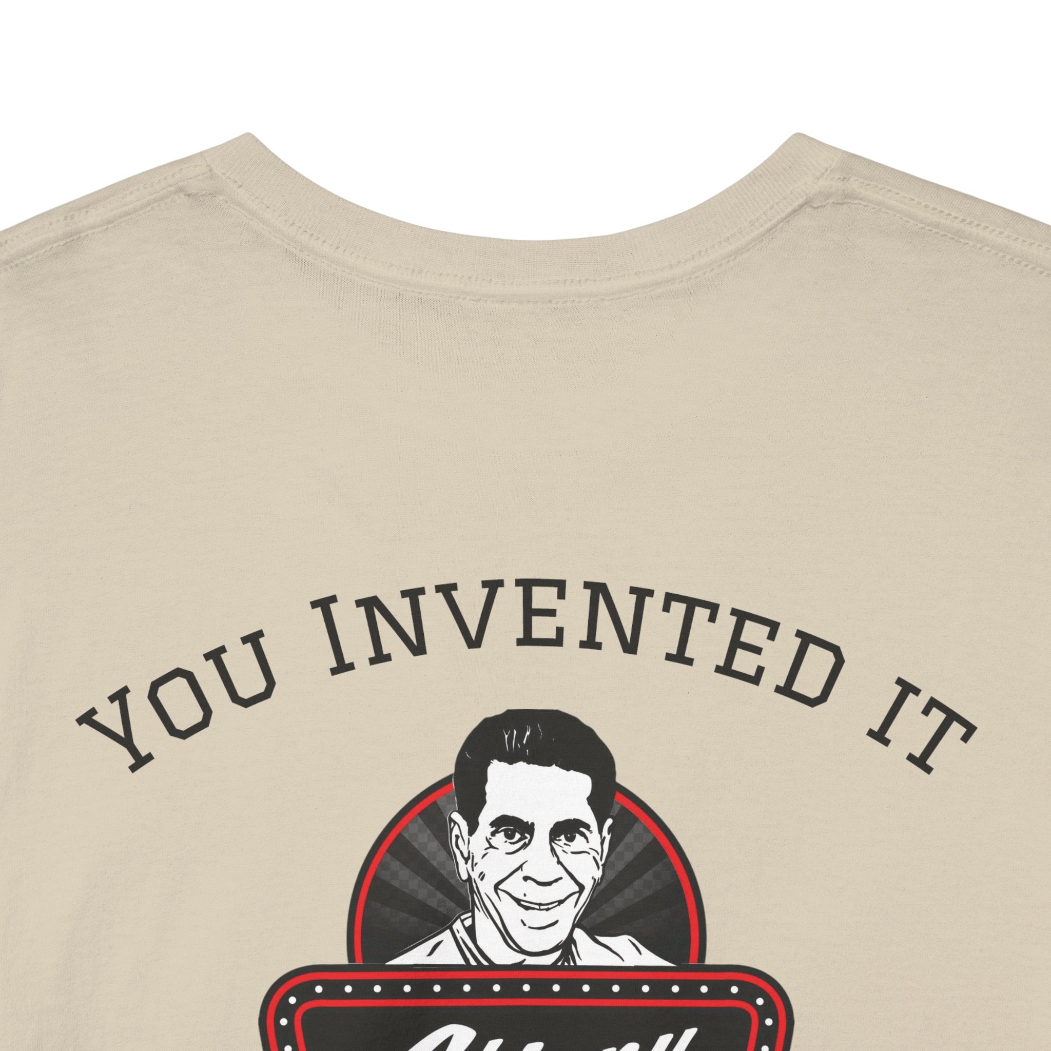 Beige t-shirt with a graphic of a person's face and text 'YOU INVENTED IT' on a white background