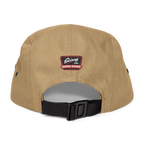 Beige cap with a black strap and a logo on the back against a white background