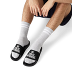 Person wearing white socks with black text 'WE CAN GO ANYWHERE' on a white background
