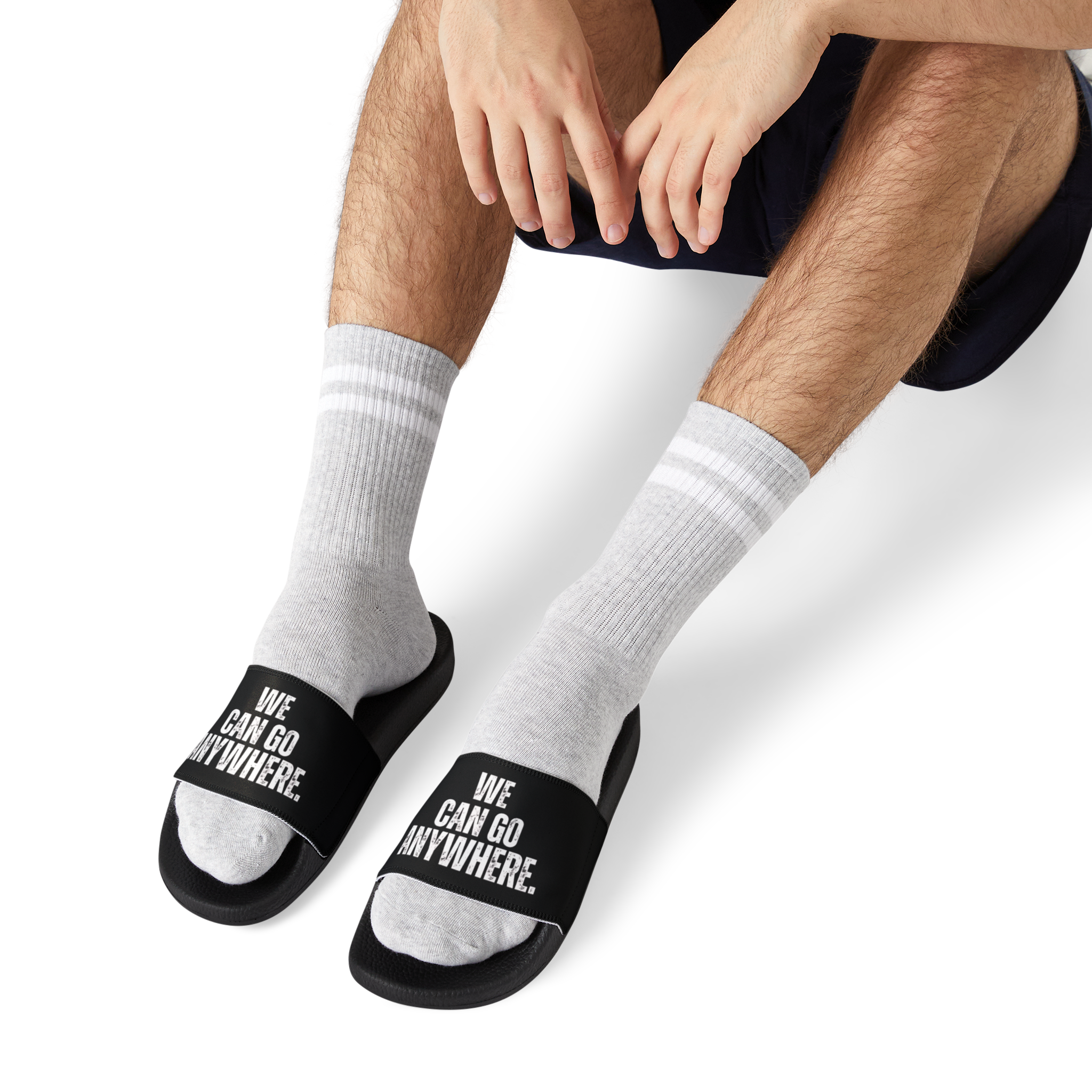 Person wearing white socks with black text 'WE CAN GO ANYWHERE' on a white background