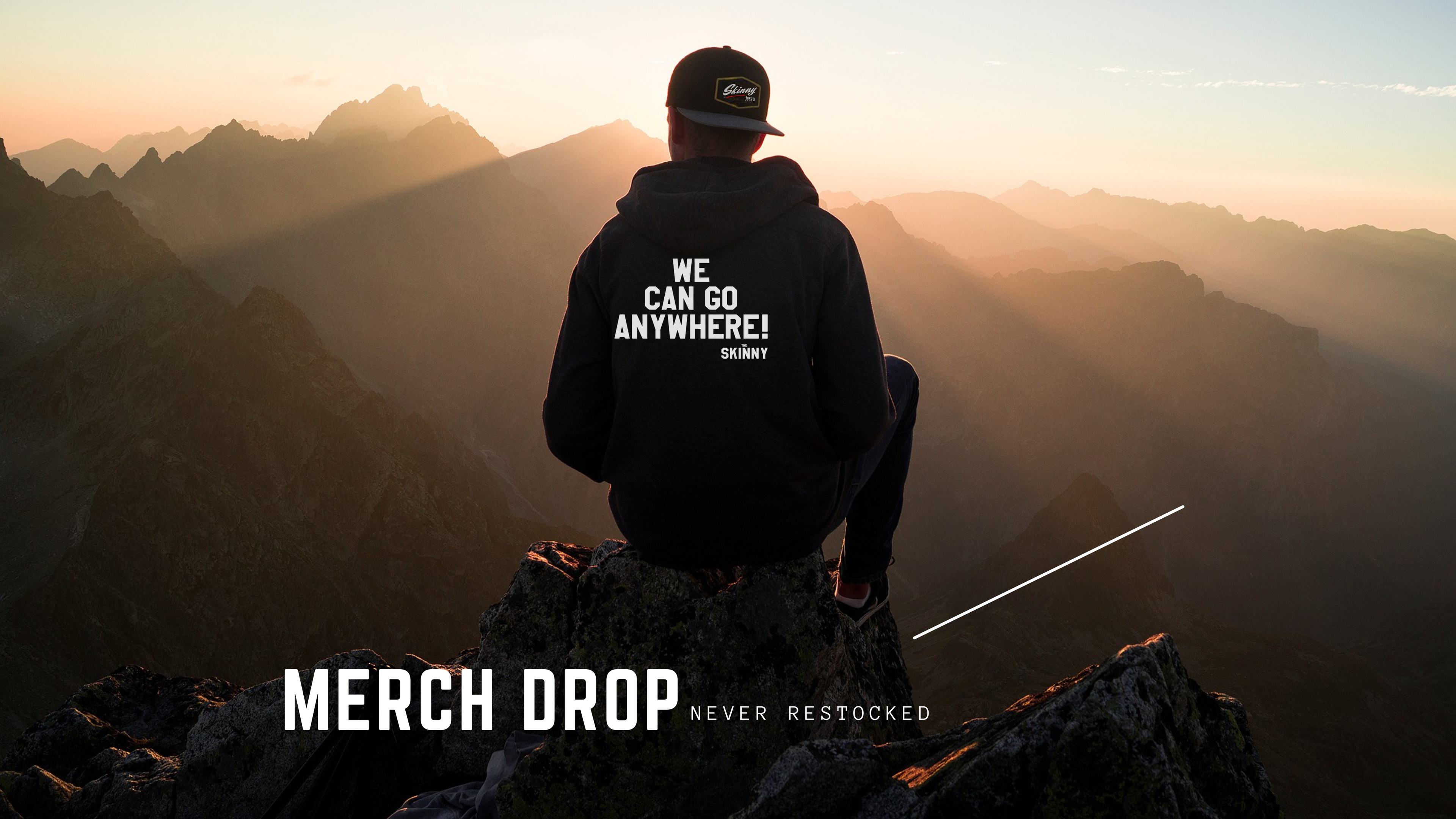 Person sitting on a mountain with 'We Go Nowhere' hoodie, sunset in the background