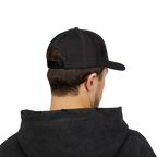 Person wearing a black cap and black hoodie on a white background