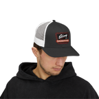 Man wearing a black and white cap with a logo on a white background