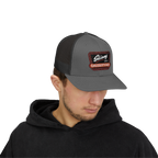 Person wearing a gray cap with a logo on a white background