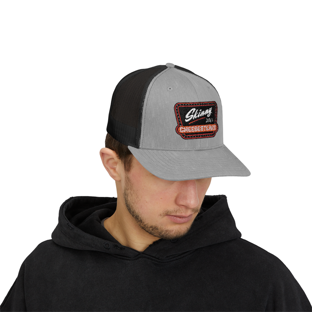 Person wearing a gray and black cap with a logo on a white background