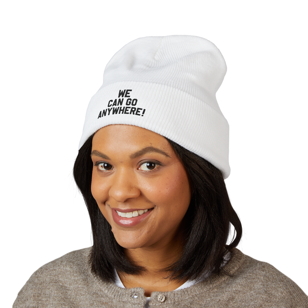 Person wearing a white beanie with 'WE CAN GO ANYWHERE!' text on a white background