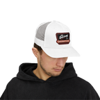 Man wearing a white trucker cap with a logo on a white background