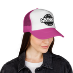 Person wearing a pink and white cap with 'Skinny' logo on a white background