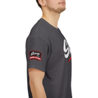 Person wearing a dark gray t-shirt with a logo on the sleeve against a white background